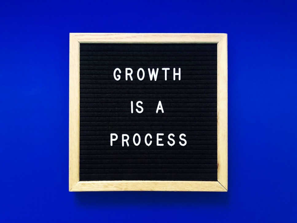 Growth is a Process Blackboard Letters Written Blue Background