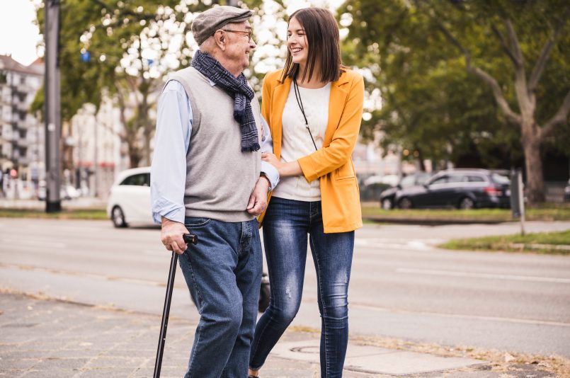 Senior Man Old Male Grandfather Being Helped Street by Young Helpful Happy Woman