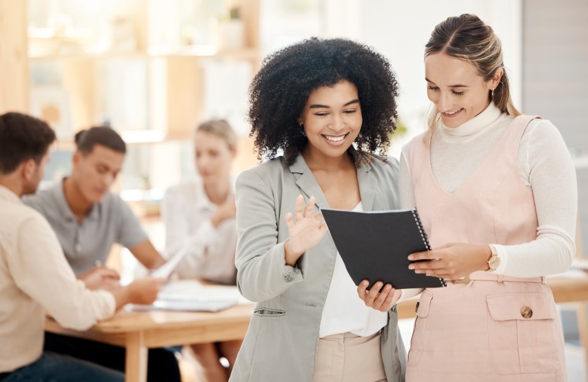 Professional Women Smiling Showing Visual Identity Book Guidelines