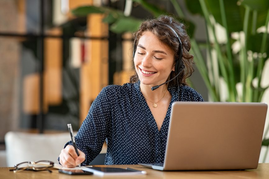 Responsive Successful Customer Service Woman Headphones Phone Laptop Writing Taking Notes