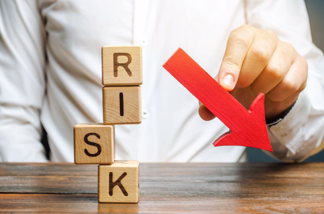 Wooden blocks with the word Risk and a down arrow. Risk management is part of business intelligence.