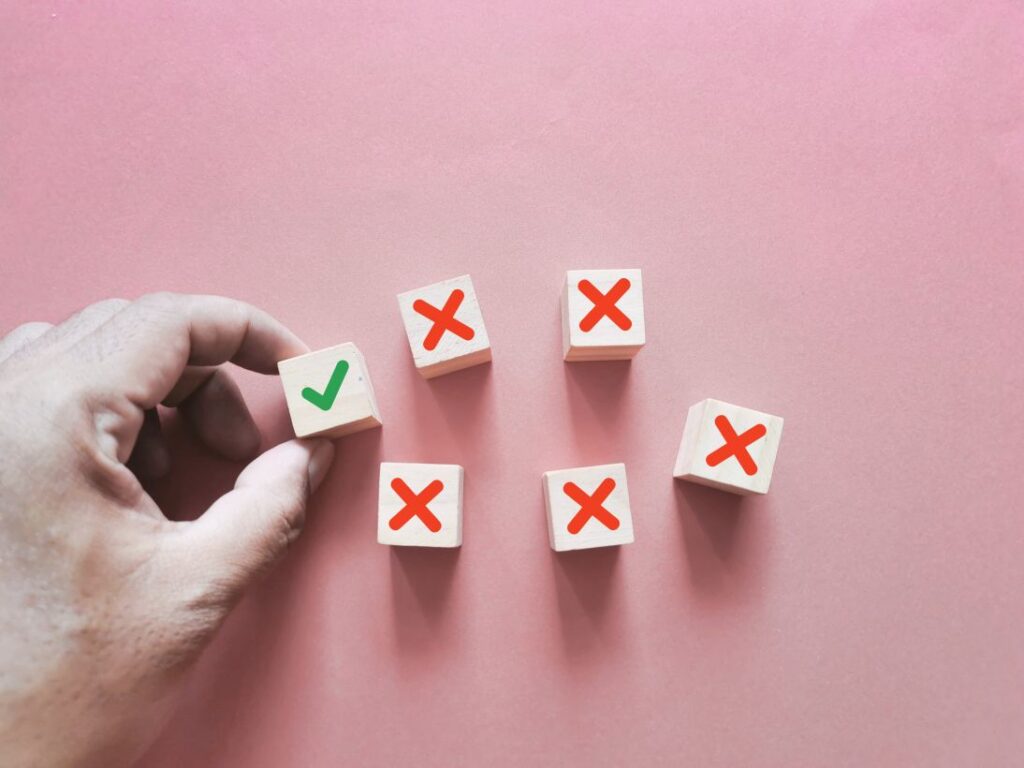 Check mark and x sign symbol on wooden cubes depicting the decision-making process