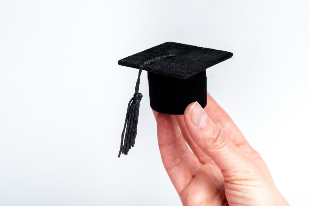 Hand Holding Miniature Cap Hat Graduate College University