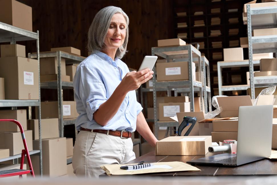 Small business owner using her smartphone to check the order from a dropshipping partner