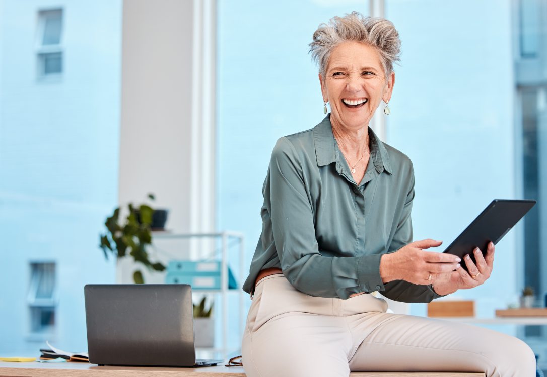 Businesswoman laughing over tablet while planning for digital marketing
