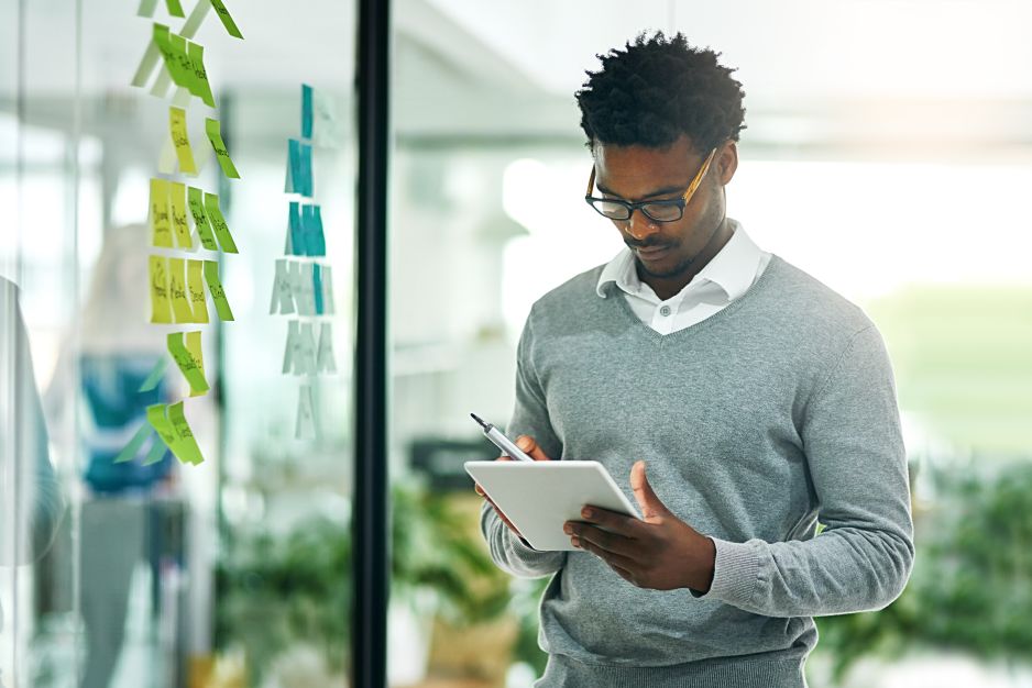 Man looking at his tablet and thinking about the digital marketing services his company needs