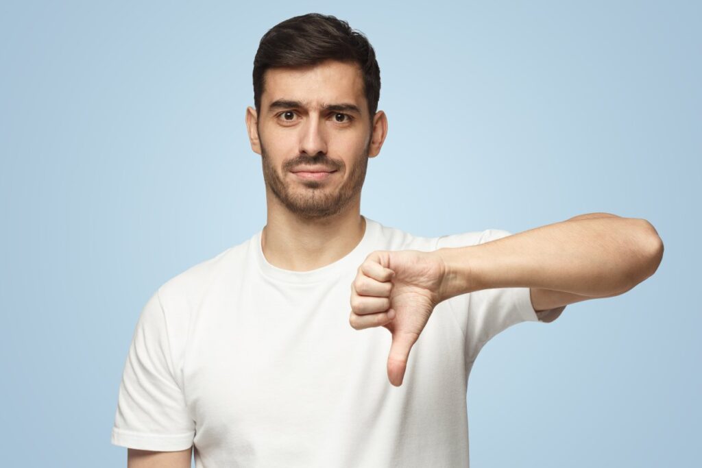 Man showing thumb down or dislike because of bad and inconsistent content