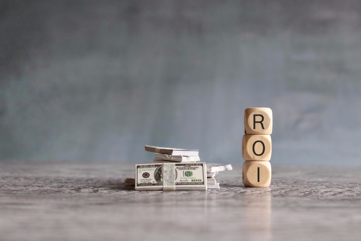 Stack of money and wooden cubes with text ROI