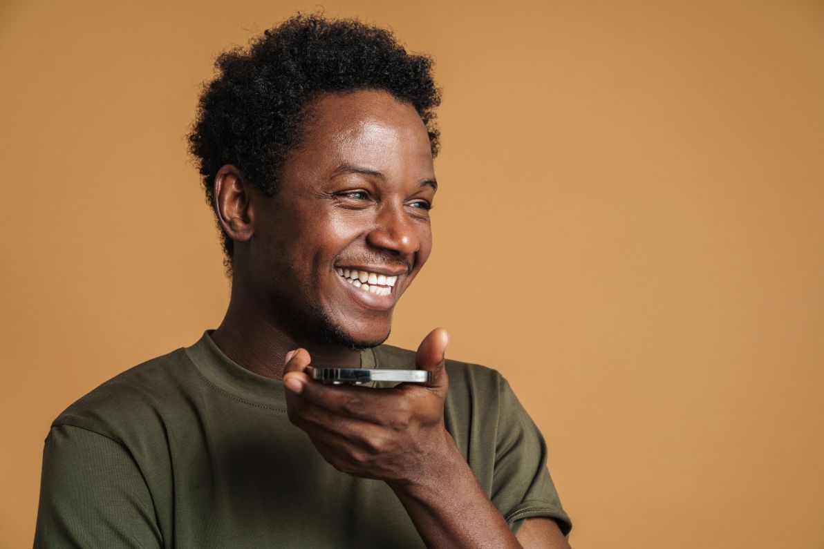 Young man holding phone near his mouth, testing for voice search optimization