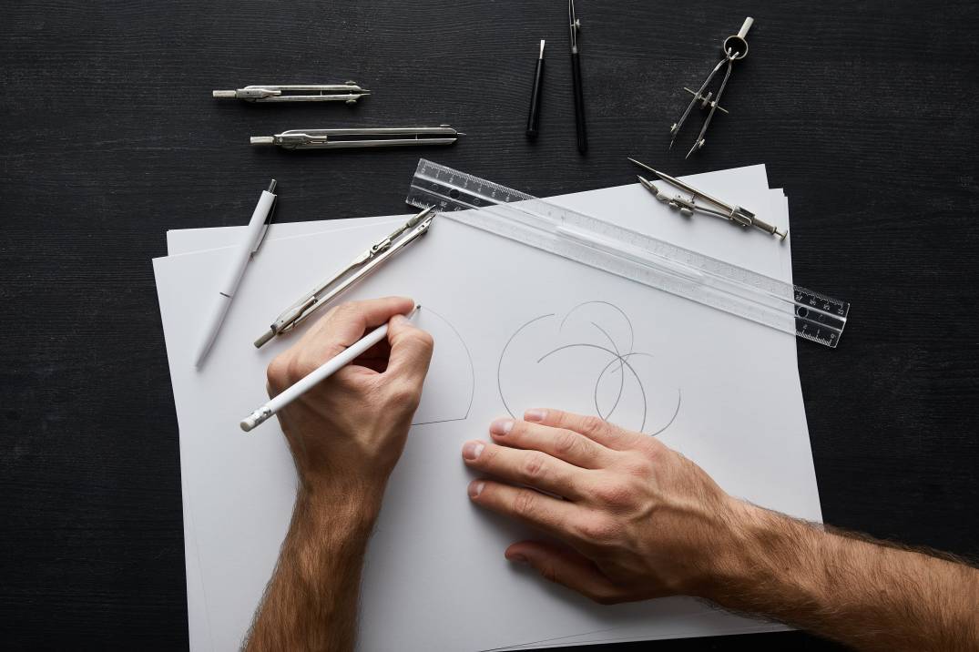 View of a professional graphic designer drafting a logo on paper using a pencil
