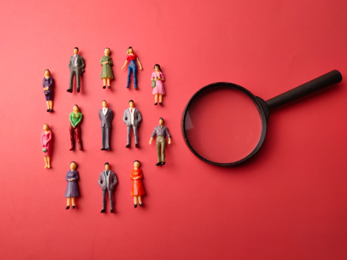 Miniature people and magnifying glass showing how to minimize visual perception bias