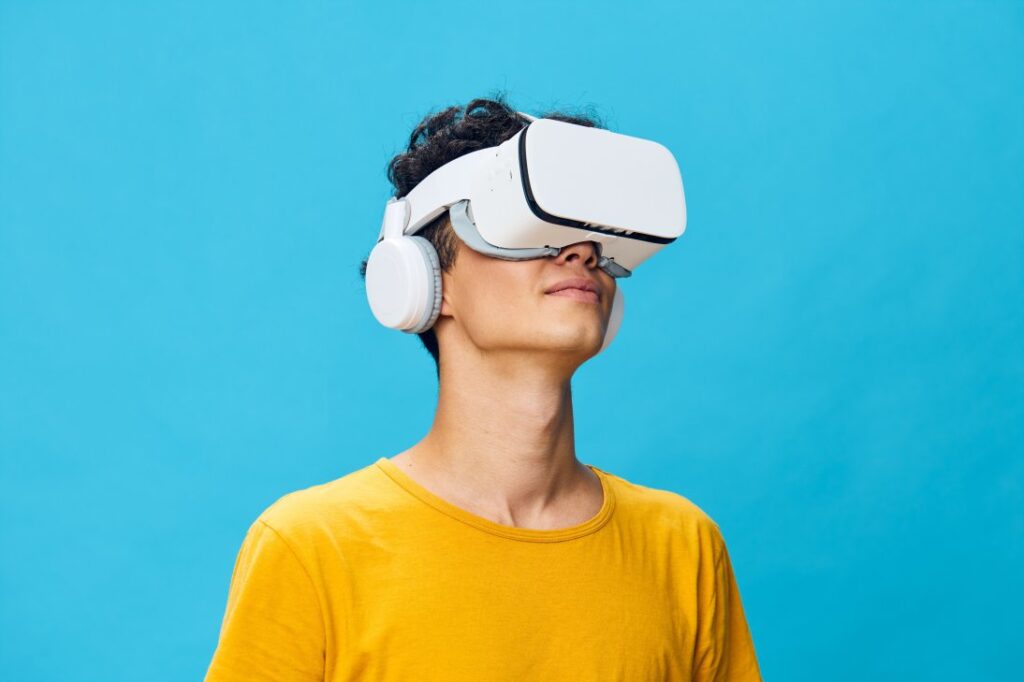 Virtual reality experience, man wearing VR headset and headphones, bright blue background, enjoying