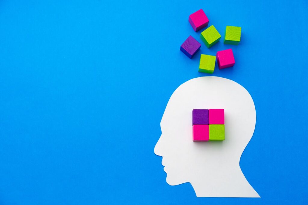 Papercut silhouette of human head with colorful constructor pieces depicting small business consulting