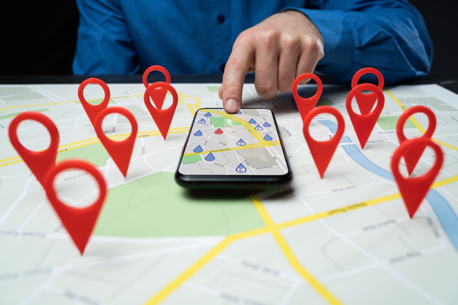 Person using smartphone with map and location pins for local SEO navigation
