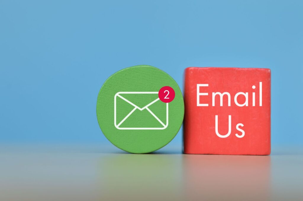 Email symbol drawn on wooden block with text EMAIL US