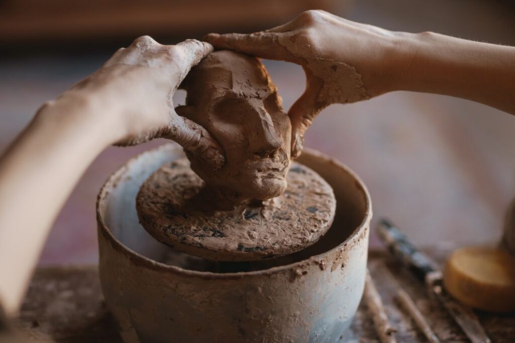 Young woman sculptor artist creating a bust sculpture