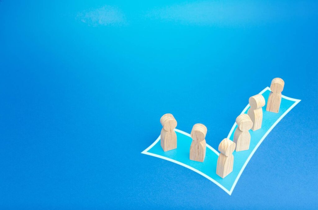 Wooden figures inside a checkmark